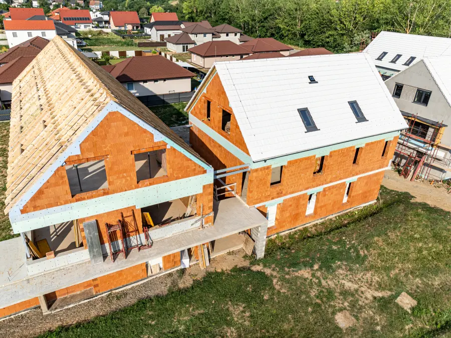 épülő szerkezetkész tégla emeletes társasház fehér tetőcseréppel