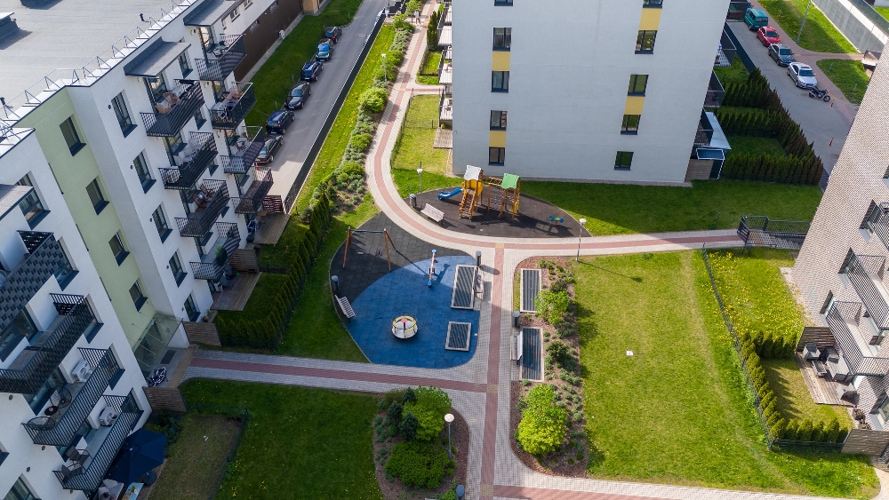 Modern lakótömbök között zöld park játszótérrel